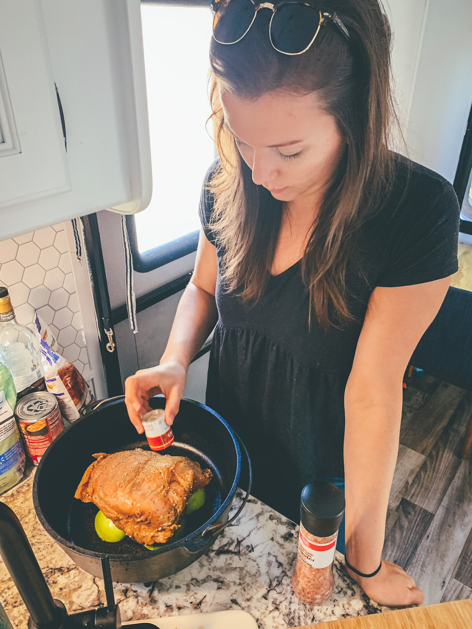 a young lady seasoning a turkey in a dutch oven as she prepares it for cooking over coals for Thanksgiving. 